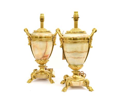 A Pair of Gilt Metal Mounted Onyx Lamp Bases, 20th century, of ovoid form with leaf-cast loop handles, on circular socles, sq
