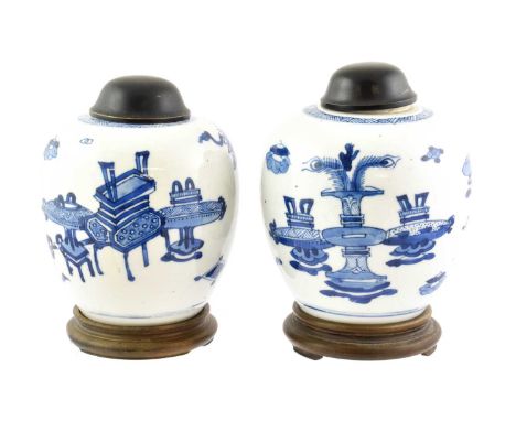 A Pair of Chinese Porcelain Ginger Jars, Kangxi, painted in underglaze blue with auspicious objects, with hardwood stands13cm