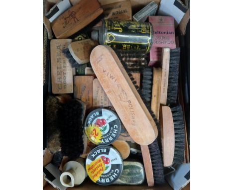 A box of vintage shoe polish brushes and tins.