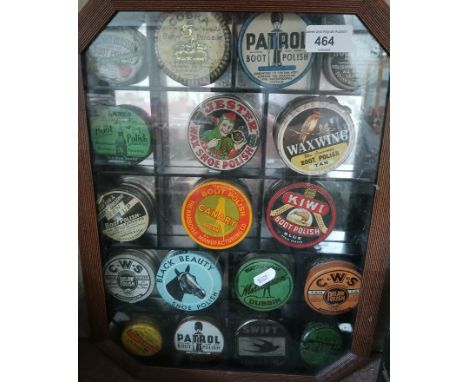 A display case of vintage shoe polish tins.