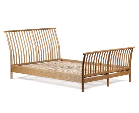 Lucien Ercolani for Ercol: A modern Ercol double bed, with curved slatted back and footboard, 150 x 215 x 72cm high.