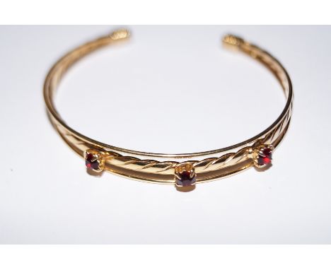 Gold plated bangle with red gem stones
