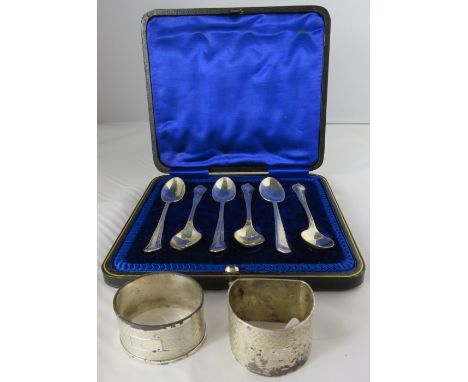 A cased set of six silver tea spoons, Sheffield 1917; a silver D shaped engine turned napkin ring; and a cased metal napkin r