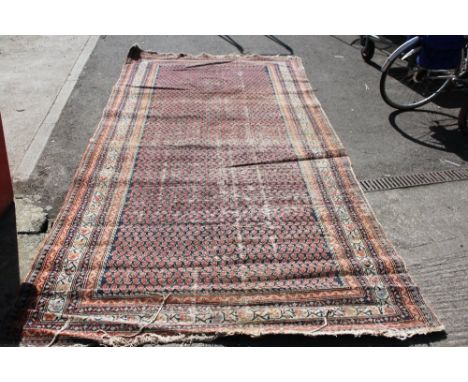 A 20th century carpet, along with a rug, with three central diamond motifs on a blue ground