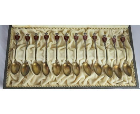 A cased set of twelve silver gilt and enamel tea spoons by Marius Hammer, stamped makers mark and 930S, the finial in the for