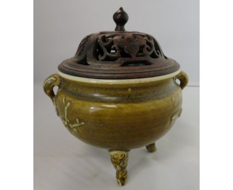 A Chinese green glazed incense burner with pierced handles and lid, on a tripod base, 13cm high, 13.5cm diameter