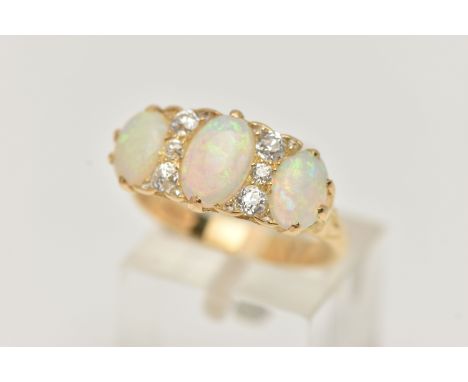 AN EARLY 20TH CENTURY OPAL AND DIAMOND RING, set with graduating oval opal cabochons, measuring from approximately 8.4mm x 5.