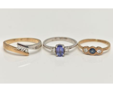 THREE 9CT GOLD GEM SET RINGS, the first a three stone diamond ring in a bi colour bypass mount, hallmarked 9ct Birmingham, ri