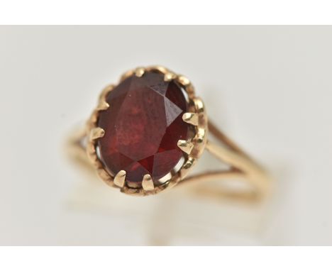 A 9CT GOLD GARNET SET RING, oval cut garnet in a double four claw setting, measuring approximately 10.0mm x width 8.0mm x dep