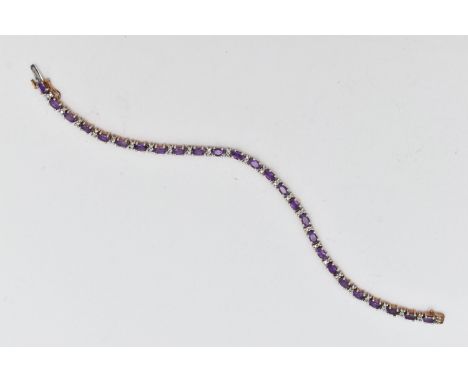 A 9CT YELLOW AND WHITE GOLD AMETHYST AND DIAMOND BRACELET, designed as a series of twenty six oval shape amethysts, interspac