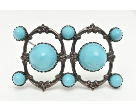 A WHITE METAL BROOCH, open work brooch set with two large blue ceramic domes and six smaller domes, scrolling mount, fitted w