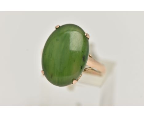 A YELLOW METAL, NEPHRITE CABOCHON RING, of an oval form, nephrite measuring approximately length 18.4mm x width 13.3mm x 4.0m