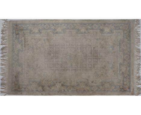 A Chinese handmade silk carpet in light beige and green colours, 155x90cm
