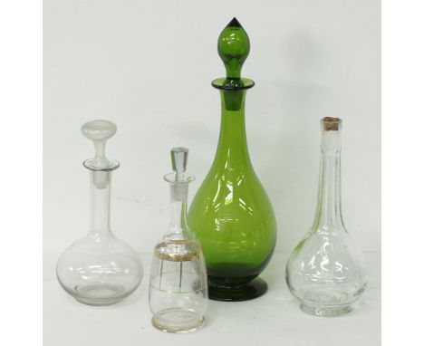 A collection of glass decanters comprising a green glass with stopper H36cm, a clear glass with stopper, a vintage KEO clear 
