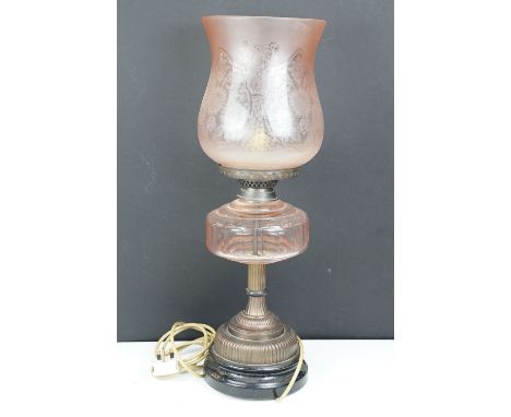 Late 19th / early 20th century oil lamp, the pink glass frosted shade with floral detail, over a glass font and gadrooned bas