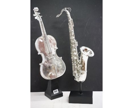 Two resin musical instrument models to include a violin and saxophone, with chrome effect finish. (Saxophone approx 62cm high