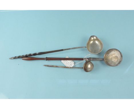 Three white metal ladles, one set with coin (smallest has a broken handle)