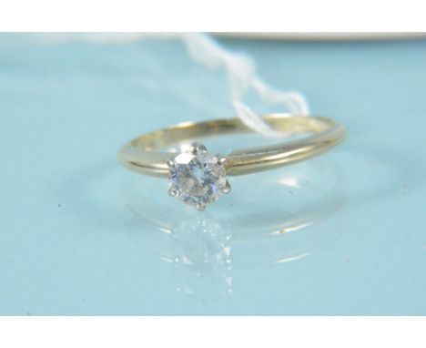 An unmarked yellow metal solitaire diamond set ring, size N, weight approx 2g