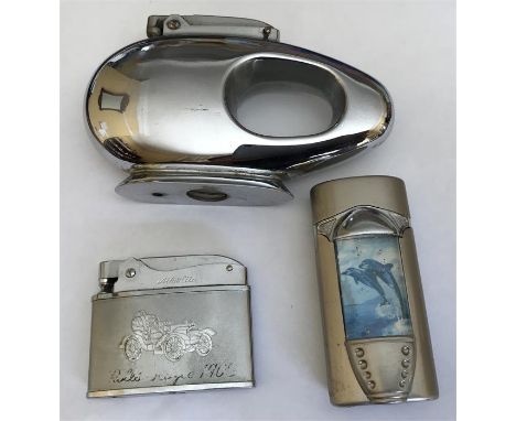 Three lighters to include a Vanguard table lighter, Omo, Tommy trench lighter and a turbo flame dolphin lighter.