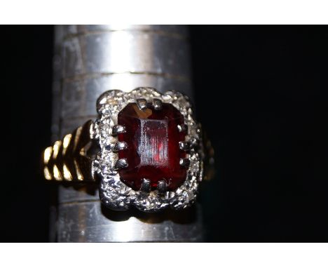 18ct gold ring set with central Ruby(?) and surrounding diamonds on a raised platinum mount. Size O