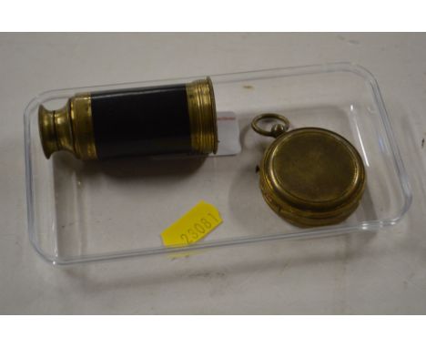 A brass cased compass and an eye glass