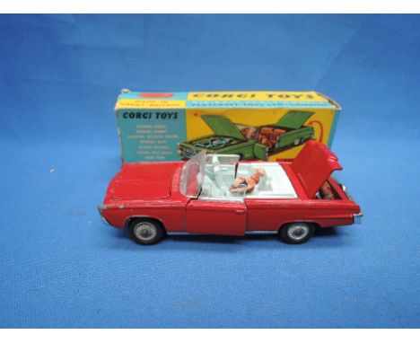 A Corgi die-cast, Chrysler Imperial convertable having red body and light blue body along with passengers and golf clubs in t