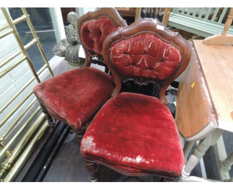 A pair of late Victorian mahogany dining chairs having shaped back with burgundy velvet back panel and upholstered seats on c