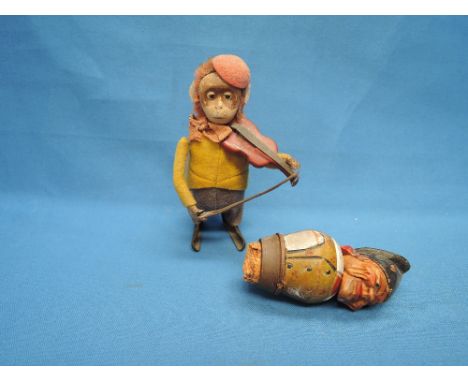 A Schuco clockwork and tin plate monkey playing violin and a treen bottle stopper modelled as an alpine man
