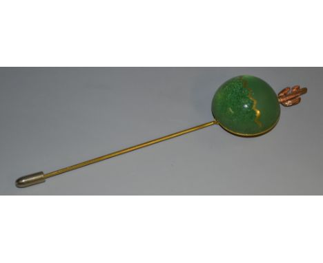 A Daum gilt brass stick pin, designed by Joseph Hilton McConnico, applied with a green glass hemisphere, surmounted with a ro