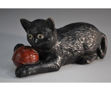 A Bretby model of a black kitten playing with a ball of red wool, green glass eyes, 24cm long, impressed sunburst mark, model