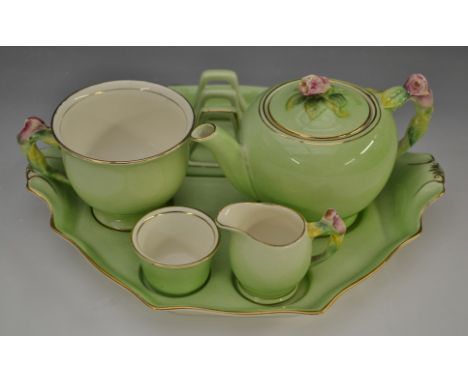 A Royal Winton breakfast solitaire, comprising tea pot, tea cup, milk jug, sugar basin and toast rack on a shaped octagonal t