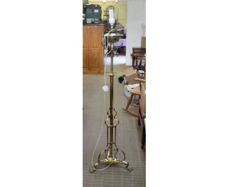 A PROBABLE EARLY 20TH CENTURY ADJUSTABLE BRASS STANDARD LIGHT FITTING, supported on cast claw feet, now converted to electric