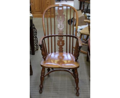 A LATE 19TH / EARLY 20TH CENTURY DOUBLE COMB BACKED ARMCHAIR with solid seat, supported four splayed turned legs united with 
