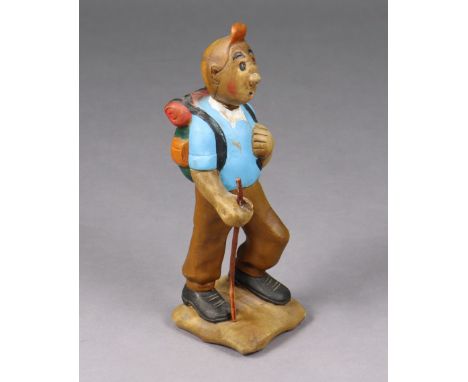 A vintage carved &amp; painted wooden figure of Tin-tin, dressing in hiking gear holding a stick, on rocky base, 12¼” high.