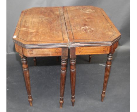 A pair of Regency mahogany card tables, each fold top with canted corners, the frieze of each with inlaid ebony lines and eac