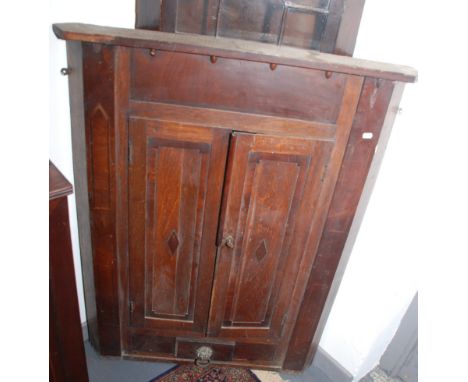 A hanging corner cupboard with blind panel doors.