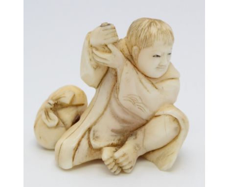 A Japanese ivory okimono, a youth seated and holding his hands at shoulder height, in which are the remains of an object. Lat