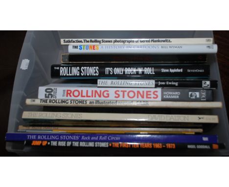 A box of Rolling Stones related books including "The Stones A History In Cartoons" by Bill Wyman.