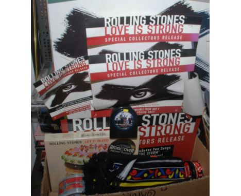 A box of Rolling Stones mugs and other collectibles and a card sign advertising the Love is Strong CD.