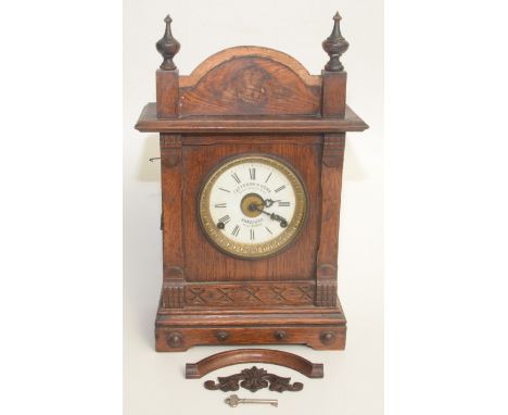 A Fattorini & Sons oak cased patent automatic alarm clock, early 20th century, height 44cm.  