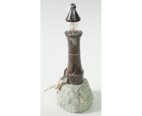 A Cornish serpentine lighthouse lamp, with a seagull perched on a stylised rock base, height 38cm. 