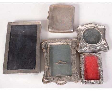 Four silver mounted photograph frames and a silver engine turned cigarette case. 