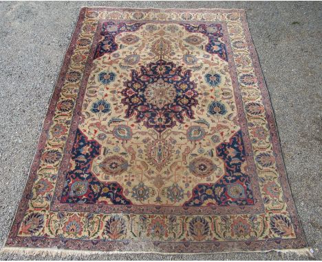 A Tabriz carpet, north west Persia, the ivory field with an indigo lobel pole medallion, palmettes, vines, flowerheads and le