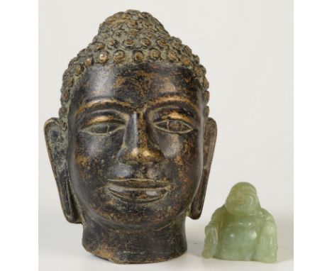 A metal Buddha's head, height 11.5cm and a hardstone seated buddha, possibly jade, height 3.5cm.