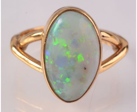 An 18ct gold ring set a large opal.    Condition report:  Ring size Q.very small flaws to opal,  gold good condition