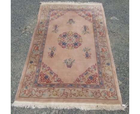 A Chinese 'Kayam' carpet, with a circular polychrome floral medallion and vases of flowers, within a scrolling vine and flowe