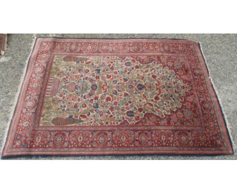 A Kashan rug, west Persia, the ivory field with a central vase of flowers, trees of life, cypress trees, flowering vines and 
