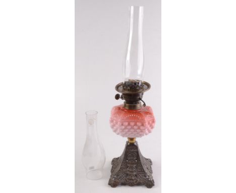 An Edwardian Duplex oil lamp, with pink opaque glass font and cast metal base, with spare glass chimney, total height 58.5cm.