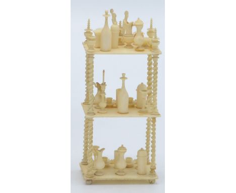 A miniature Anglo Indian ivory whatnot, the shelves covered with bottles, candlesticks, jugs, cups and saucers, height 10cm.