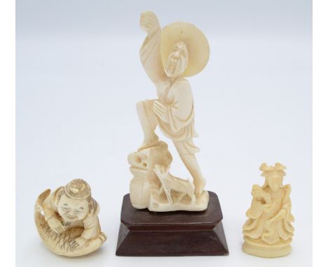 A Japanese carved ivory figure of a smiling man kneeling on a fish, height 3.5cm, together with an ivory figure of a man and 